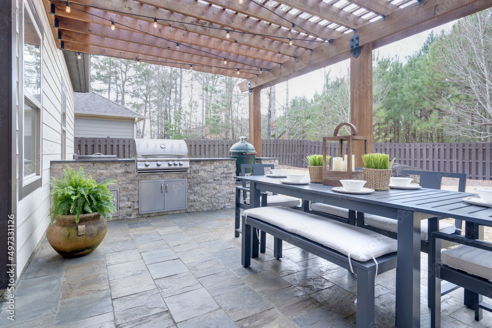 Outdoor patio with a pergola, dining set, built-in grill